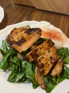 Orange and brown sugar candied pork chops on collard greens with poached eggs